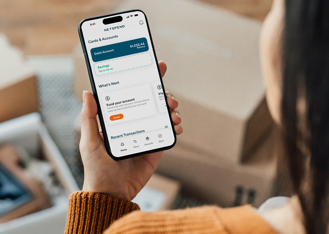 Woman holding an iPhone showing her account balance in the Netspend appt